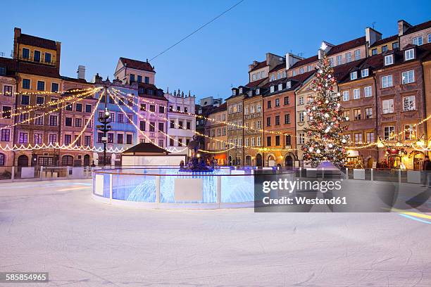 poland, warsaw, old town square with ice rink during christmas time in the evening - pista di pattinaggio su ghiaccio foto e immagini stock