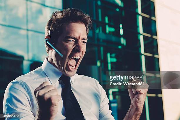 excited businessman with clenched fists screaming outside office building - 悲鳴を上げる ストックフォトと画像