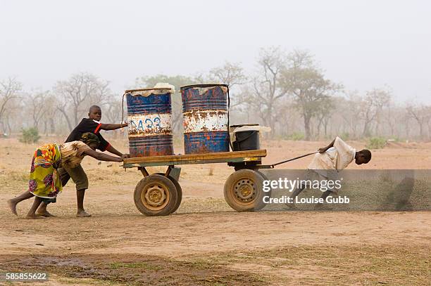 Water collectors push their cart of water filled drums laboriously homewards.
