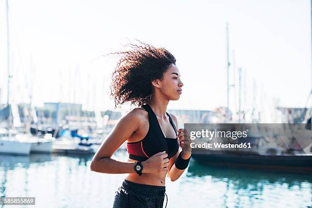 spain, barcelona, jogging young woman in front of the harbour - ropa de deporte fotografías e imágenes de stock