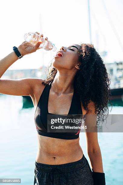 young jogger having a rest drinking water out of a bottle - standing water fotografías e imágenes de stock