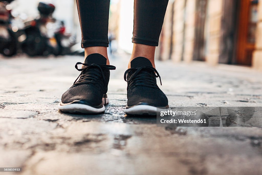 Black sneakers of sportive young woman, close-up