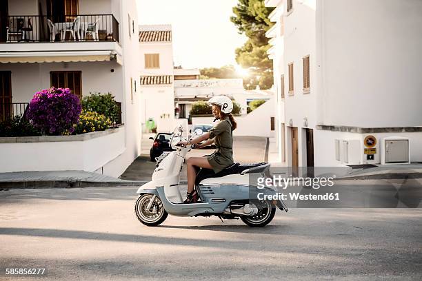 spain, majorca, alcudia, woman on motor scooter - motor scooter foto e immagini stock