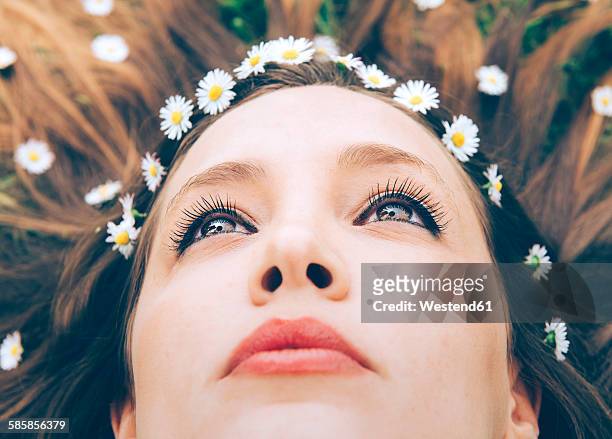 young woman lying on grass with daisies in the hair, close-up - lying on back photos - fotografias e filmes do acervo