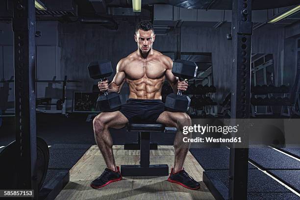 physical athlete doing dumbbell bench presses - bench press stock pictures, royalty-free photos & images