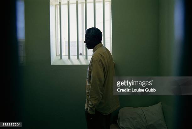 Nelson Mandela stands at the window of the cell in Robben Island Prison where he was incarcerated for more than two decades. He was held as a...