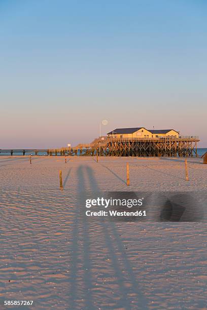 germany, st peter-ording, pile dwelling on the beach by backlight - sankt peter ording - fotografias e filmes do acervo