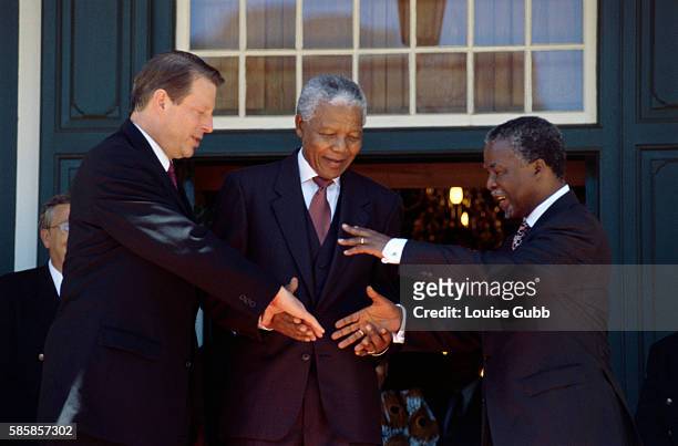 South African President Nelson Mandela facilitates a handshake between future president Thabo Mbeki and American Vice President Al Gore. Gore is...