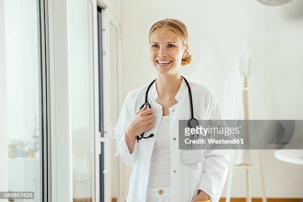 smiling female doctor with stethoscope - german blonde 個照片及圖片檔