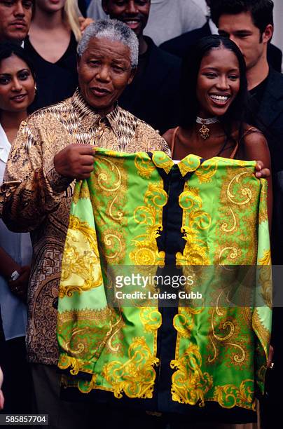 Fashion models gather as Naomi Campbell presents Nelson Mandela with a green Versace shirt. Former President of South Africa and longtime political...