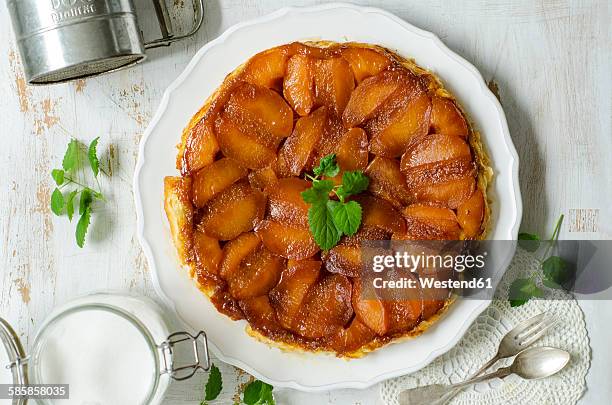 plate with tarte tatin garnished with mint leaves - apple cake stock pictures, royalty-free photos & images