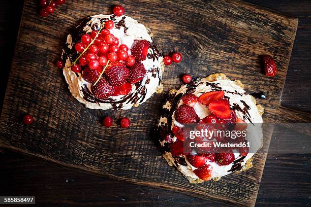 Pavlova with whipped cream, fruit topping and chocolate sauce