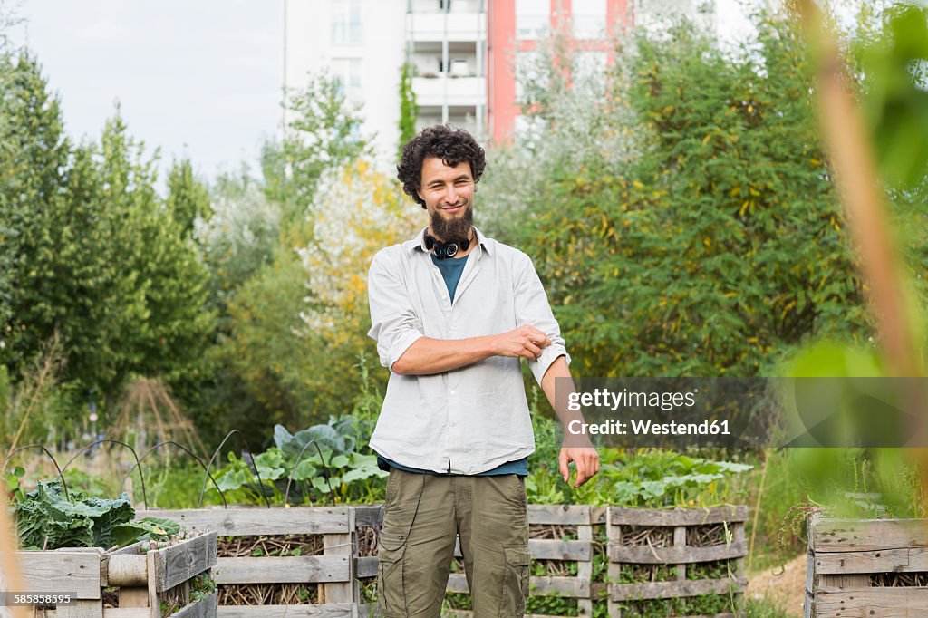 Young man standing in an urban garden