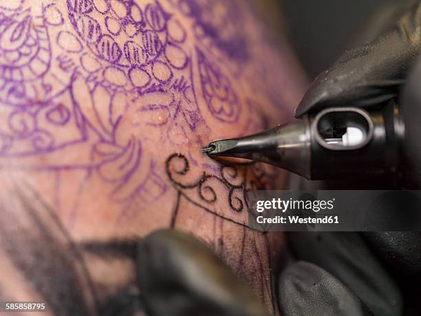 tattoo artist at work - tatouage stockfoto's en -beelden