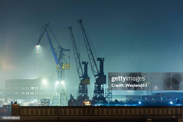 germany, hamburg, harbour cranes at port of hamburg by night - port of hamburg stock pictures, royalty-free photos & images