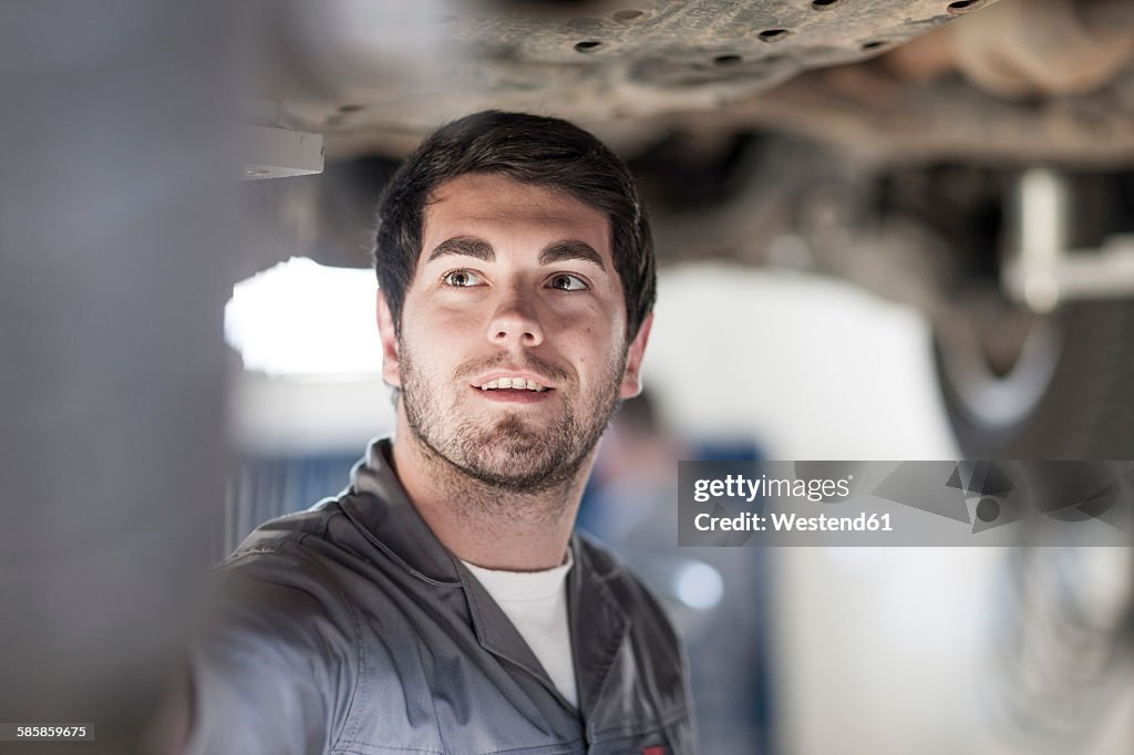 Car mechanic at work in repair garage
