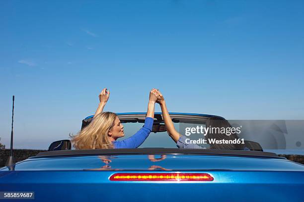south africa, two women hand in hand in a convertible - toyota south africa motors stock pictures, royalty-free photos & images