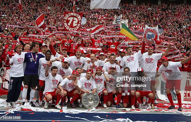 Die Mannschaft des FC Bayern präsentiert sich mit der Meisterschale vor der FC Bayern Fankurve Fussball Deutsche Meisterschaft des FC Bayern Munchen...