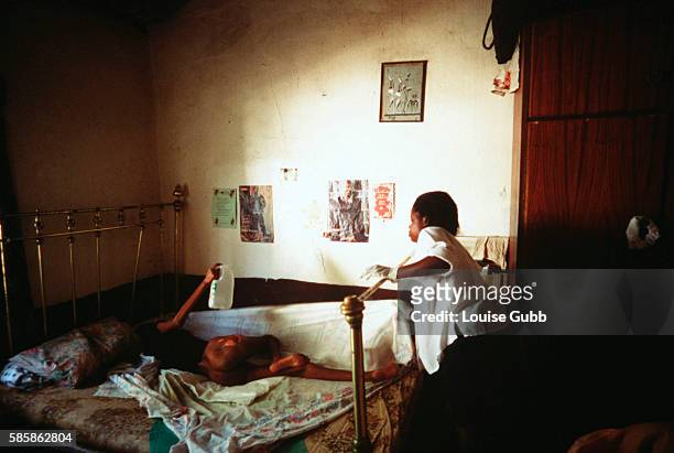 Hospital caregiver makes her first visit to Pumzile, age 20, who has contracted AIDS and is now bedridden, has partial paralysis in the legs, and has...