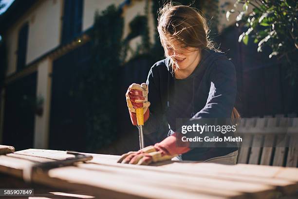 woman treating a pallet for upcycling - diy stock-fotos und bilder