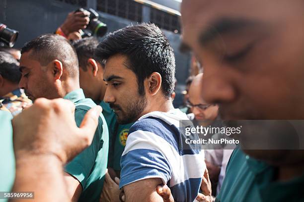 Tahmid Khan a student at the University of Toronto, in connection with a deadly siege in a cafe in Dhaka last month are surrounded by police officers...