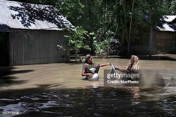 Stands high-deep in flood water as he collects water from a tube wale.