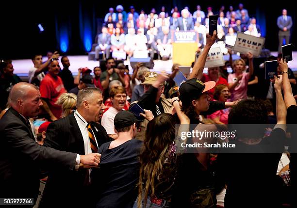 Protestors holding up copies of the Constitution are escorted out of Republican Presidential candidate Donald Trump's speech at the Merrill...