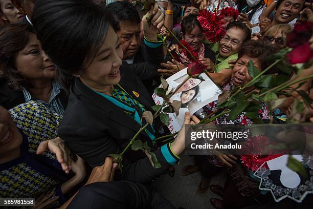 Thailand's former Prime Minister Yingluck Shinawatra receives a picture of her with her brother 'Thaksin Shinawatra' from her supporters during her...