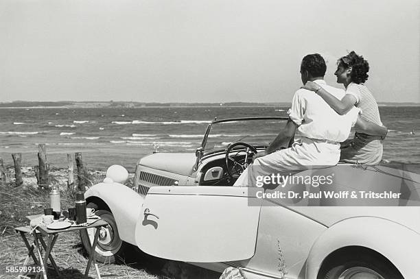Couple in convertible looking at the sea