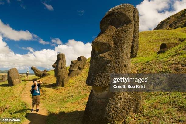 tourist photographing moai at rano raraku - moai statue stock pictures, royalty-free photos & images