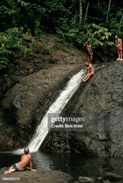 swimmers sliding down rocks - apia samoa bildbanksfoton och bilder