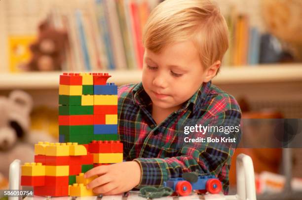 elementary boy playing with lego blocks - plastic block stock pictures, royalty-free photos & images