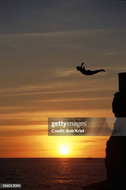 cliff diver at sunset - salto desde acantilado fotografías e imágenes de stock