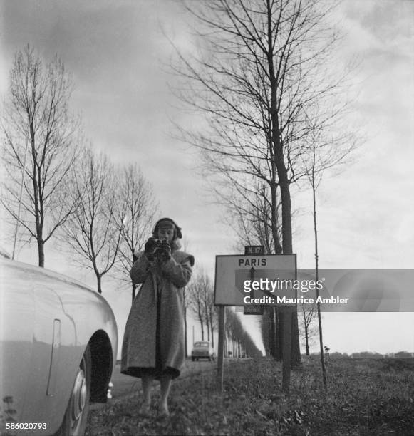Roberta Cowell , formerly Robert Cowell, taking a photograph at the side of Route Nationale 17 to Paris, March 1954. Roberta was once a Spitfire...