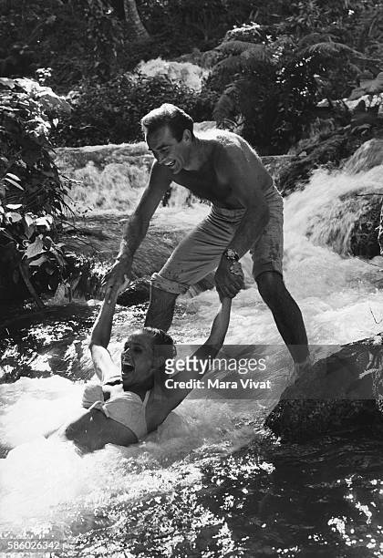Movie stars Sean Connery and Ursula Andress play in a cascading river during the filming of the James Bond movie Dr. No.