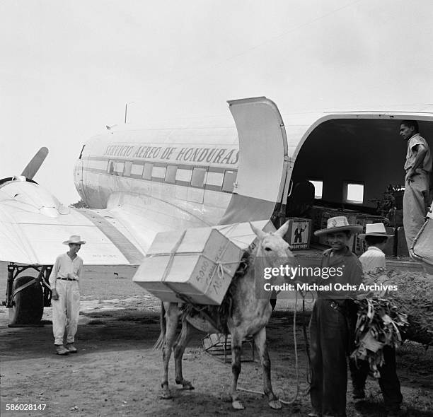 Local farmer loads his packages onto a Servicio Aereo de Honduras Plane Bay Islands, Honduras.