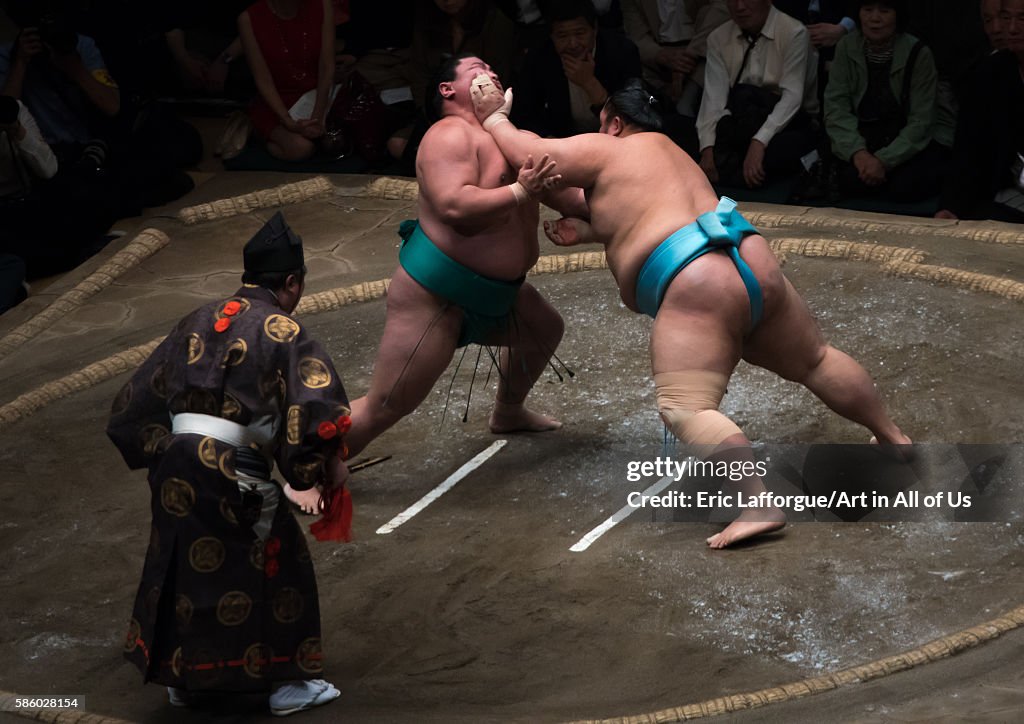 Two sumo wrestlers fighting at the ryogoku kokugikan arena, Kanto region, Tokyo, Japan...