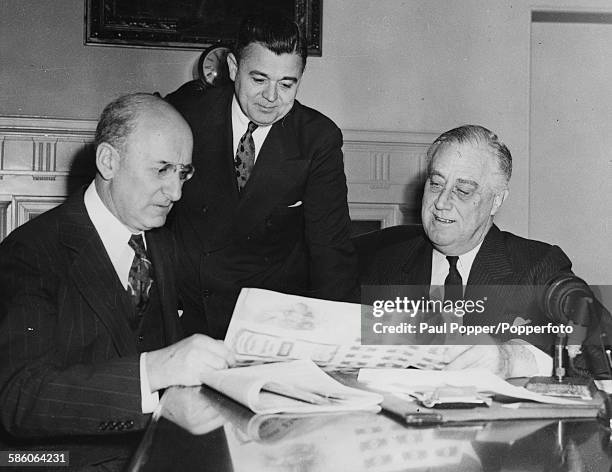 President of the United States, Franklin D Roosevelt buys the first 'Victory Loan' bond from Secretary of the Treasury Henry Morgenthau Jr , watched...