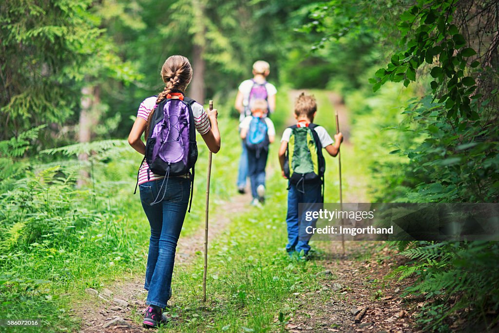 Mother and kids hiking in forest