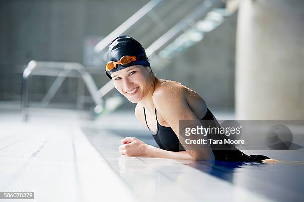female swimmer smiling to camera in pool - touca de natação - fotografias e filmes do acervo
