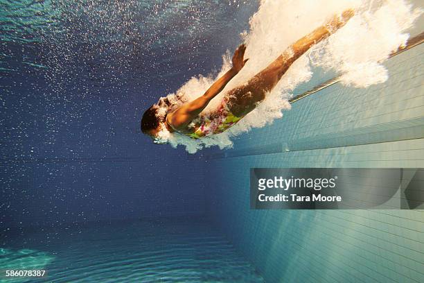 woman diving underwater - in movimento foto e immagini stock