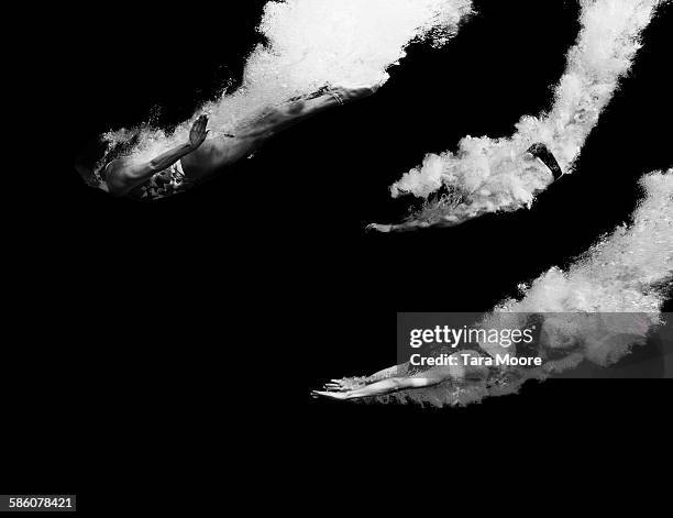 three divers diving into water - black white imagens e fotografias de stock