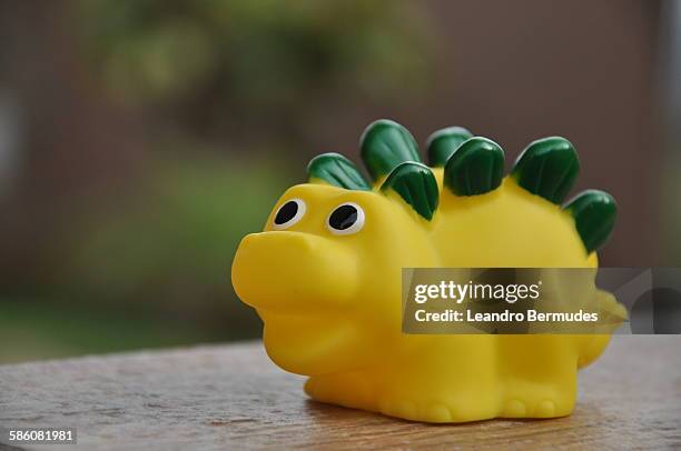 yellow toy dinosaur - leandro bermudes stock pictures, royalty-free photos & images