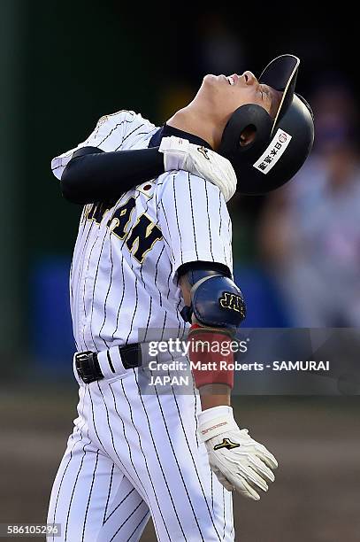 Daiki Kondo of Japan grimaces after being struck by the ball in the bottom half of the first inning in the super round game between Japan and USA...