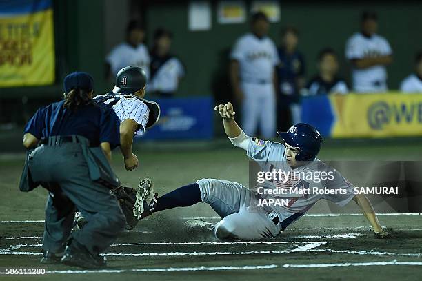 Christian Cairo of the USA slides safely to home plate in the top half of the sixth inning in the super round game between Japan and USA during The...