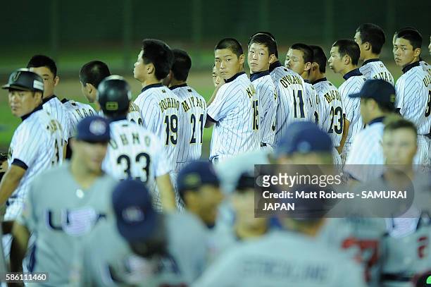 Players of Japan looks on as players of the USA celebrate after the bottom half of the nineth inning in the super round game between Japan and USA...