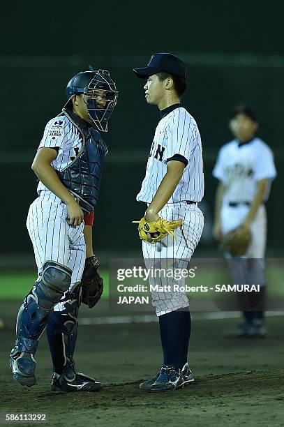 Minon Noguchi of Japan speaks with Kotaro Hoshino of Japan in the top half of the sixth inning in the super round game between Japan and USA during...