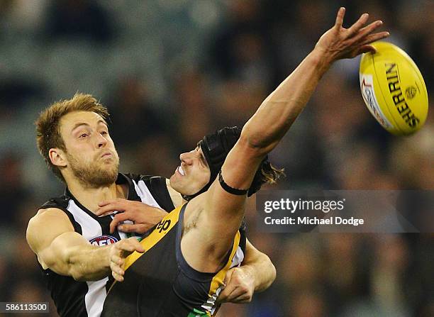 Ben Reid of the Magpies and Ben Griffiths of the Tigers compete for the ball during the round 20 AFL match between the Richmond Tigers and the...