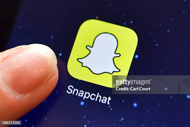 Finger is posed next to the Snapchat app logo on an iPad on August 3, 2016 in London, England.