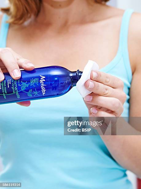 Woman using witch hazel floral water.